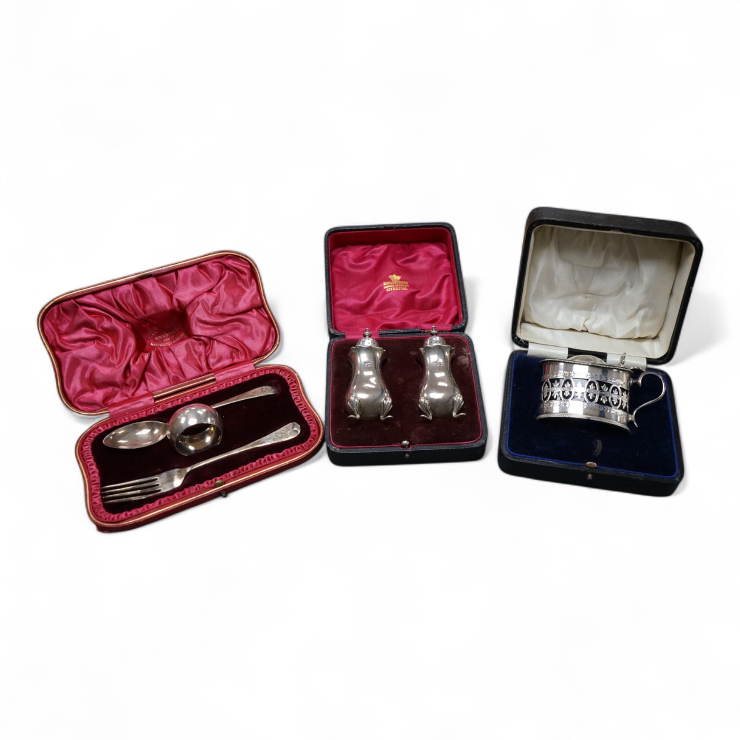 Three cased silver items including an Edwardian christening trio, a pair of George V pepperettes, Birmingham, 1916 and a George V pierced silver oval mustard pot, Birmingham, 1916.